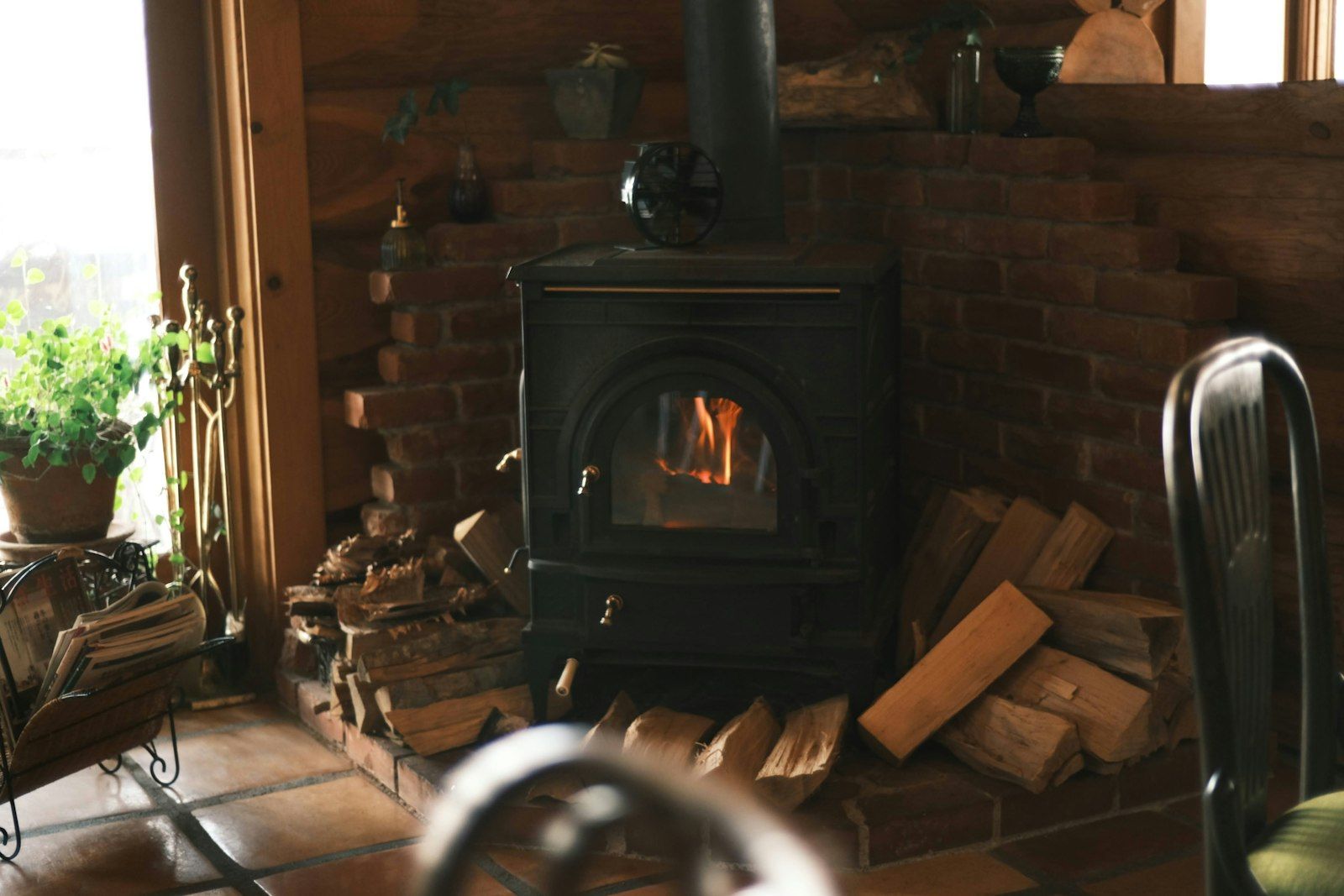 Houtkachel met brandhout in een warme woonkamer